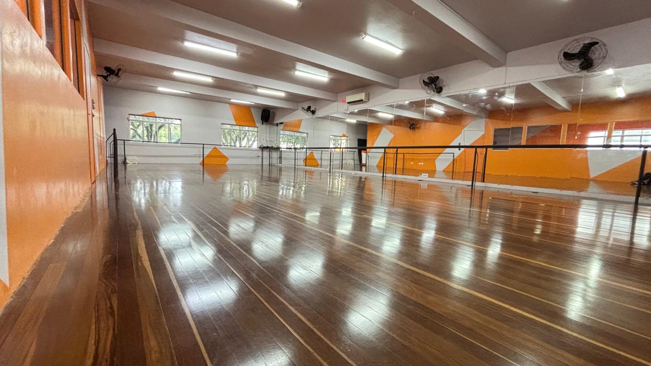 Sala de dança com piso de madeira e espelhos